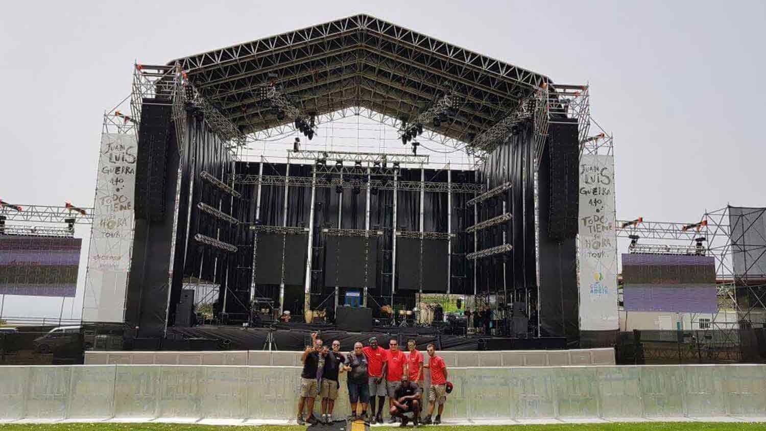 Un grupo de personas posa para una fotografía frente a un gran escenario.