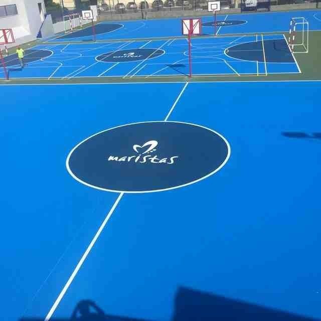 Una cancha de baloncesto azul con la palabra maristas en ella