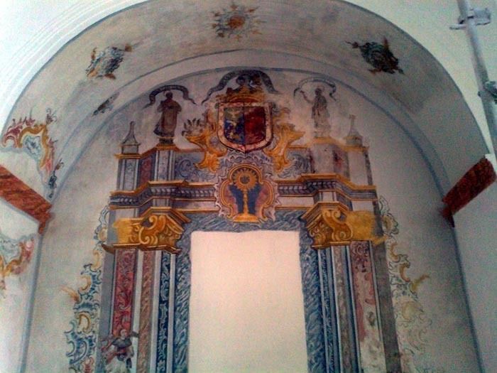 Una pintura en la pared de una iglesia con un escudo de armas