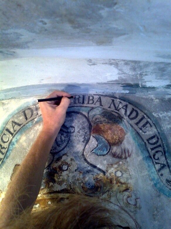 Una persona está pintando un cuadro en una pared con un bolígrafo.