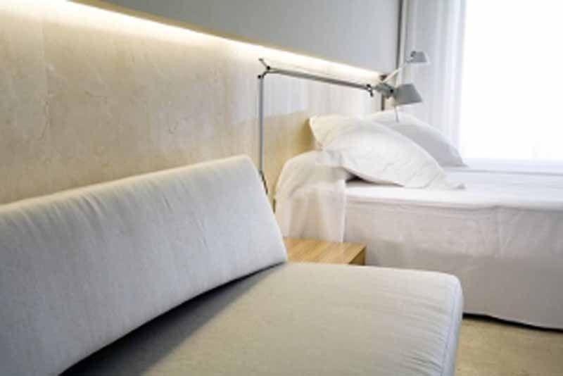 Una habitación de hotel con dos camas y un sofá.