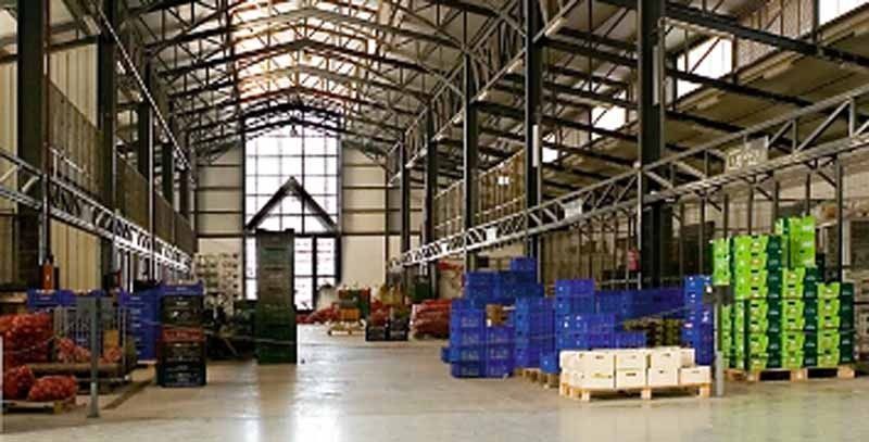 Un gran almacén lleno de muchas cajas y paletas.