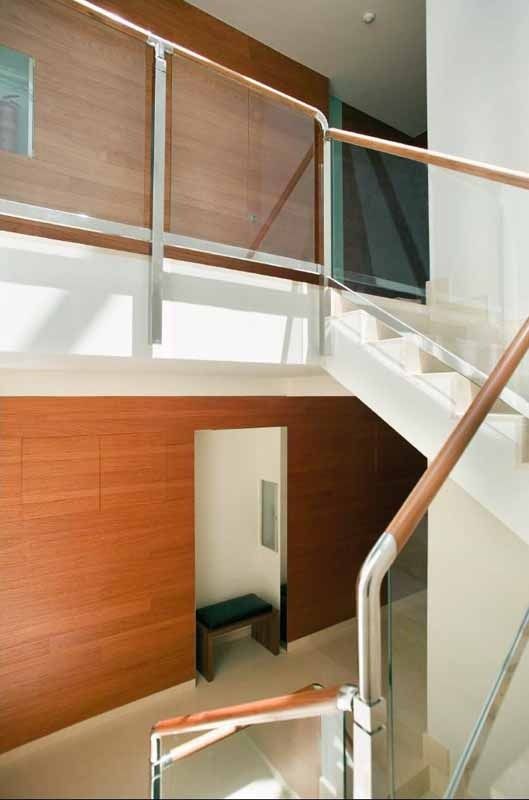 Una escalera con barandilla de madera y barandilla de cristal