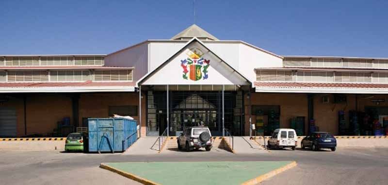 El frente de un edificio con autos estacionados enfrente.