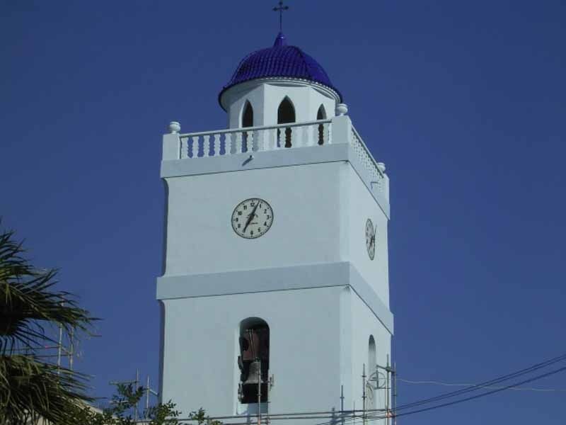 Una torre de reloj blanca con una cúpula azul en la parte superior