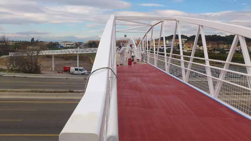 Una persona está caminando por un puente sobre una carretera.