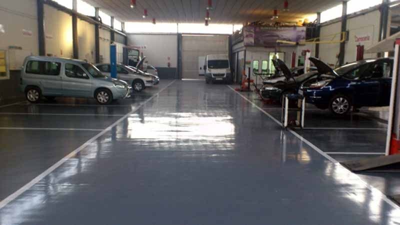 Una fila de coches están aparcados en un garaje.