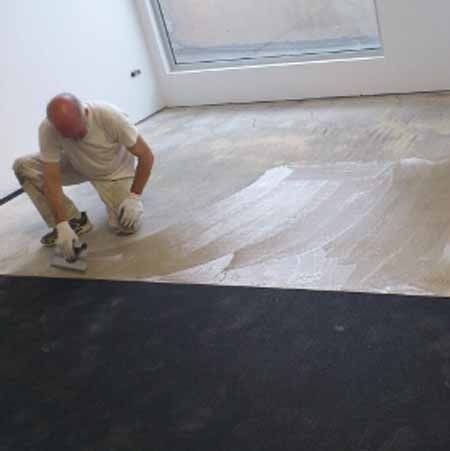 Un hombre está arrodillado en el suelo de una habitación.