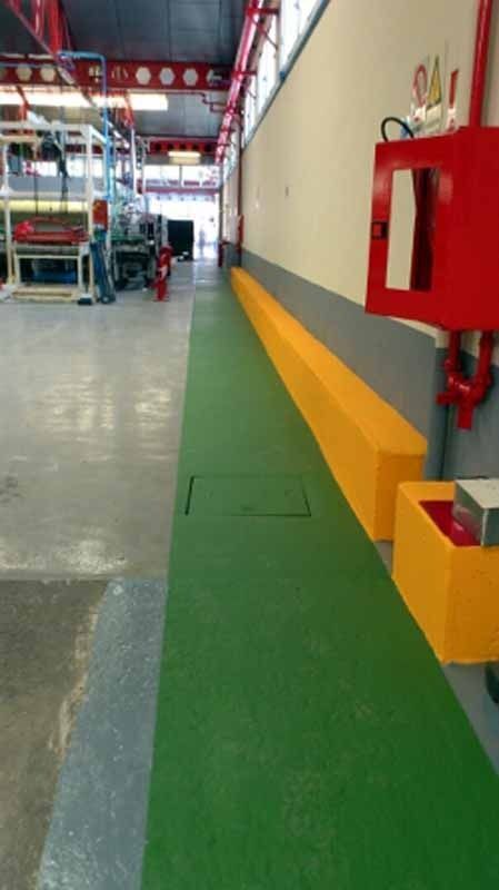 Un almacén con un suelo verde y amarillo y una boca de incendios roja.