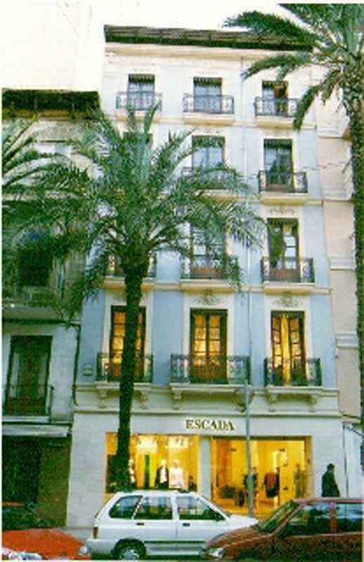 Una camioneta blanca está estacionada frente a una tienda Escada.