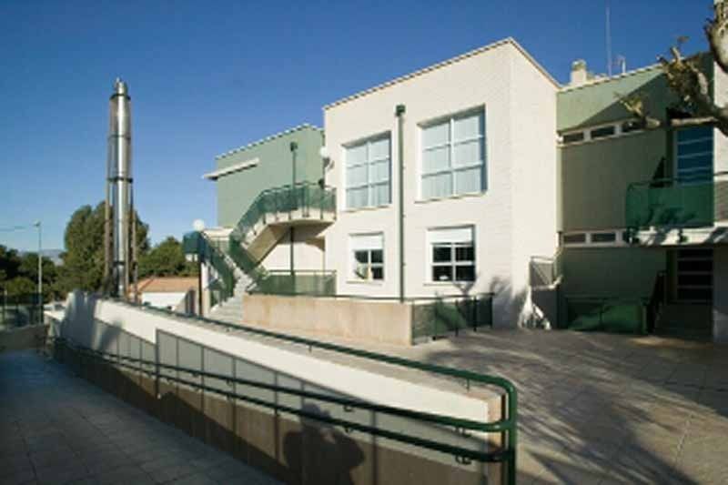 Un gran edificio blanco y verde con escaleras que conducen a él.