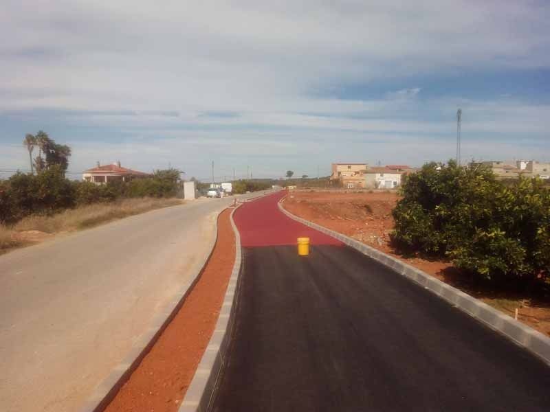 Una carretera con una franja roja al costado