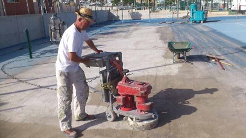 Un hombre está utilizando una máquina sobre una superficie de hormigón.