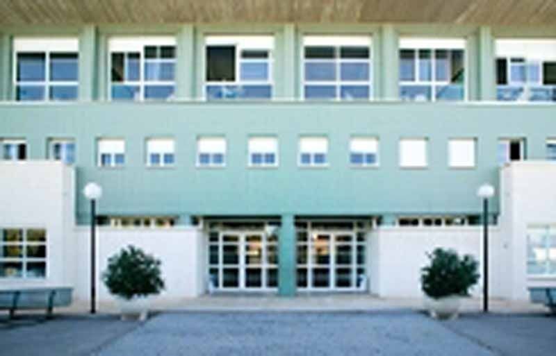 Un edificio verde y blanco con muchas ventanas.