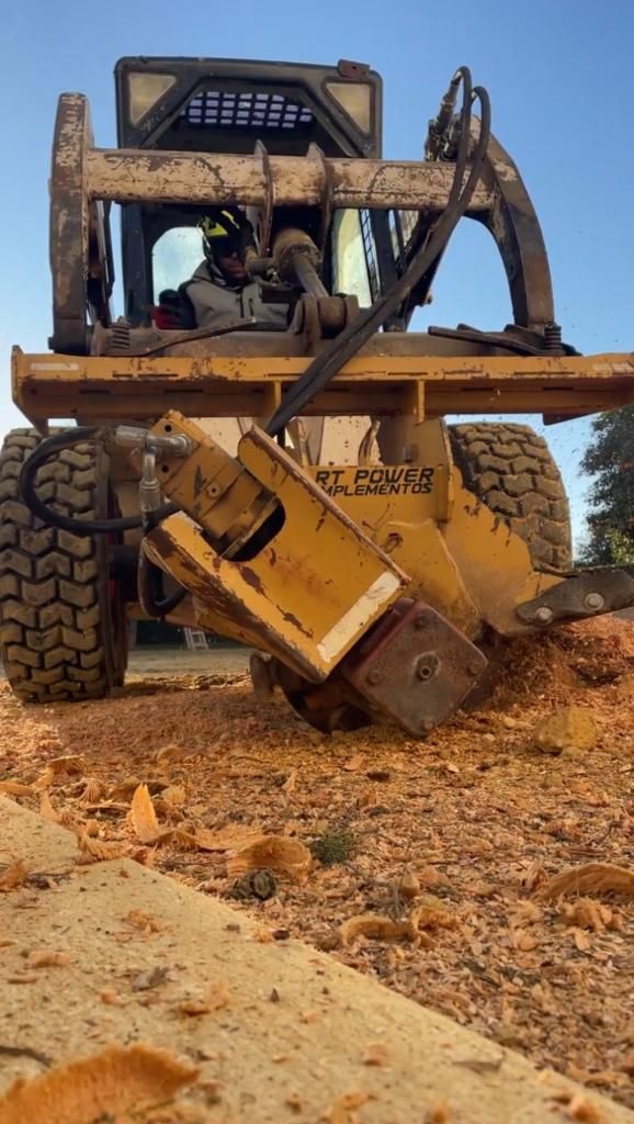 Un hombre conduce una excavadora por un camino de tierra.