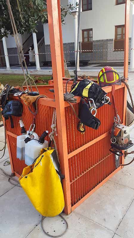 Una jaula de madera con una bolsa amarilla y un casco encima.
