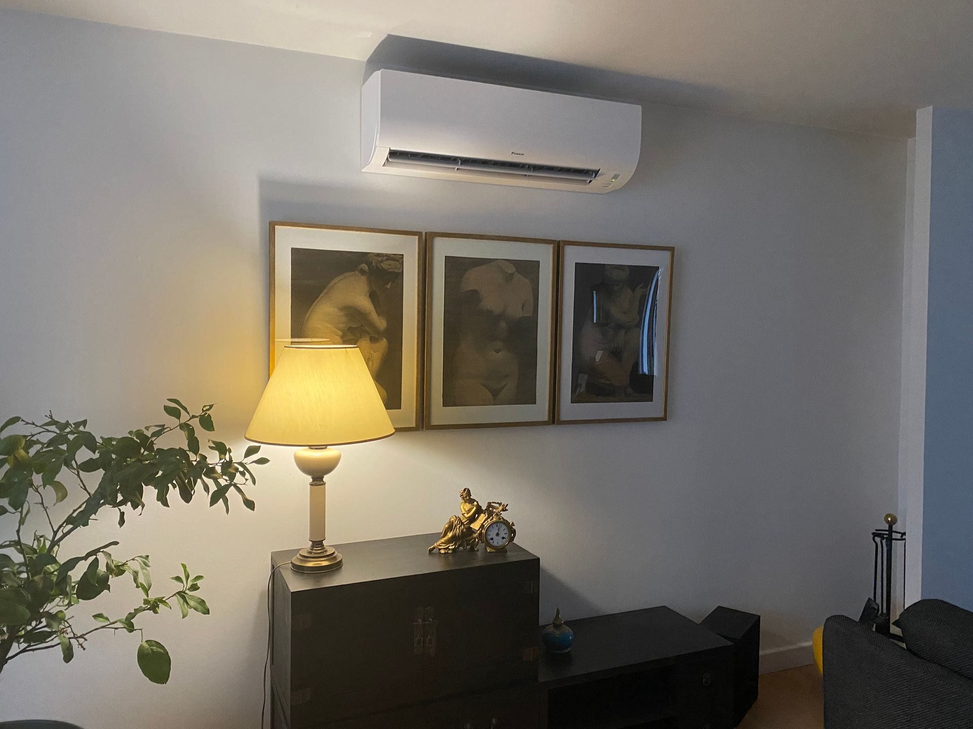 Unité intérieure de climatisation installée en haut d'un mur d'une pièce à vivre.