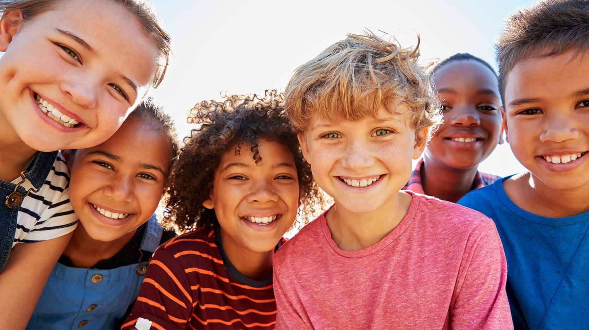 Eine Gruppe Kinder posiert gemeinsam für ein Foto und lächelt.