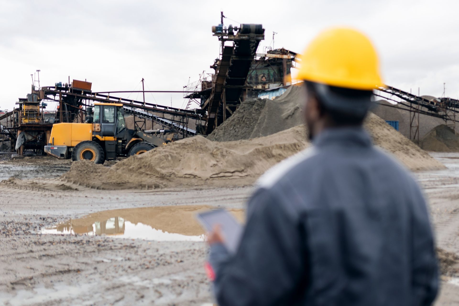 Chantier industriel, engins lourds, ouvrier avec tablette