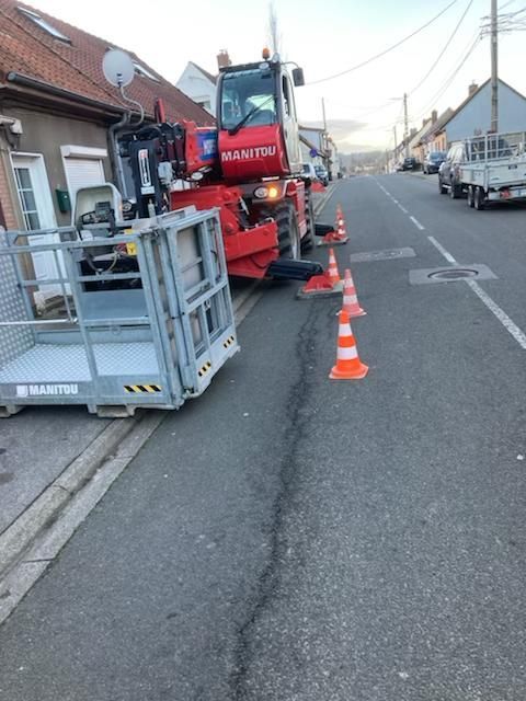 Engin rouge au travail dans une rue résidentielle