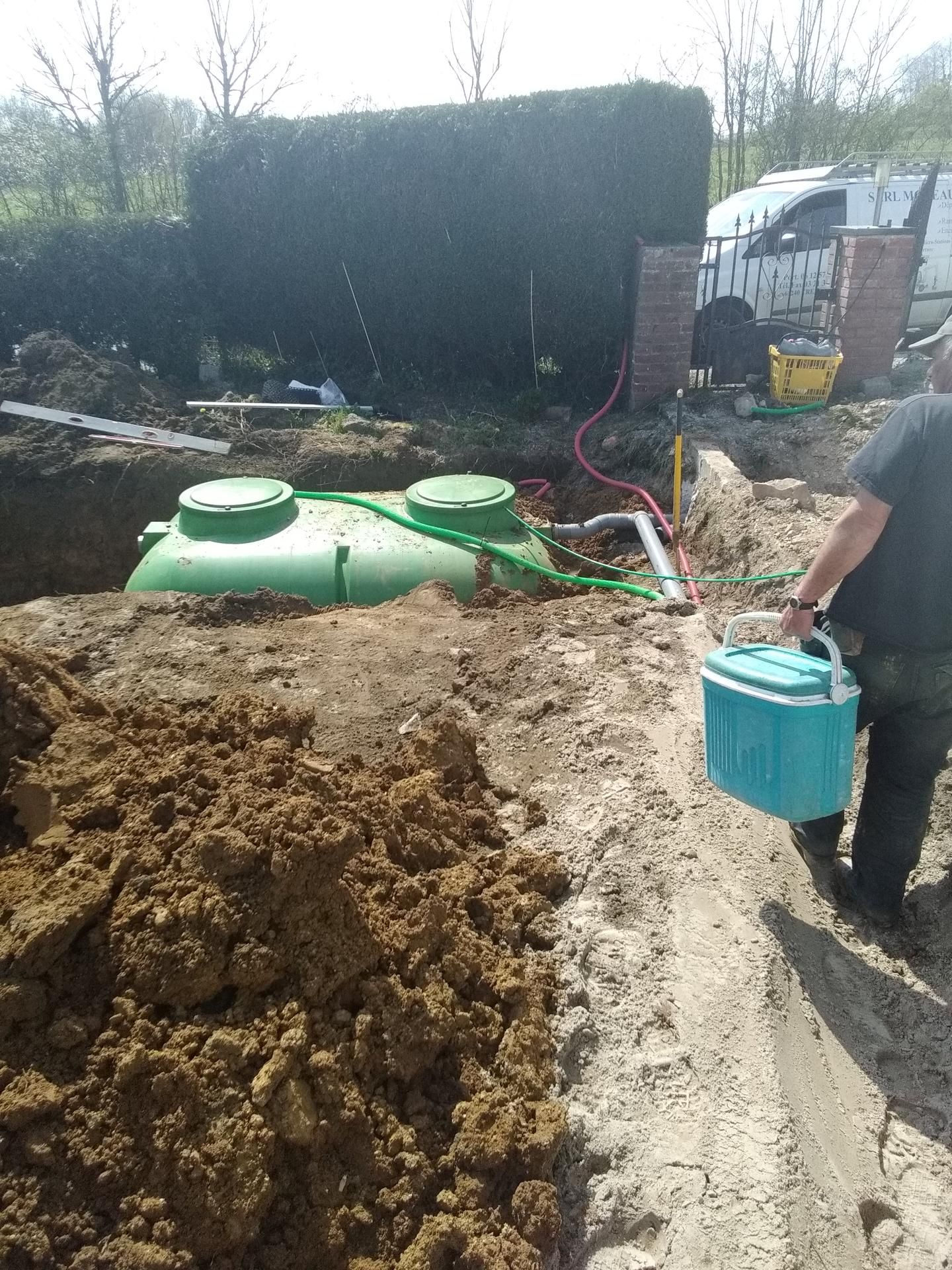 Des professionnels installent une station d'épuration chez un particulier