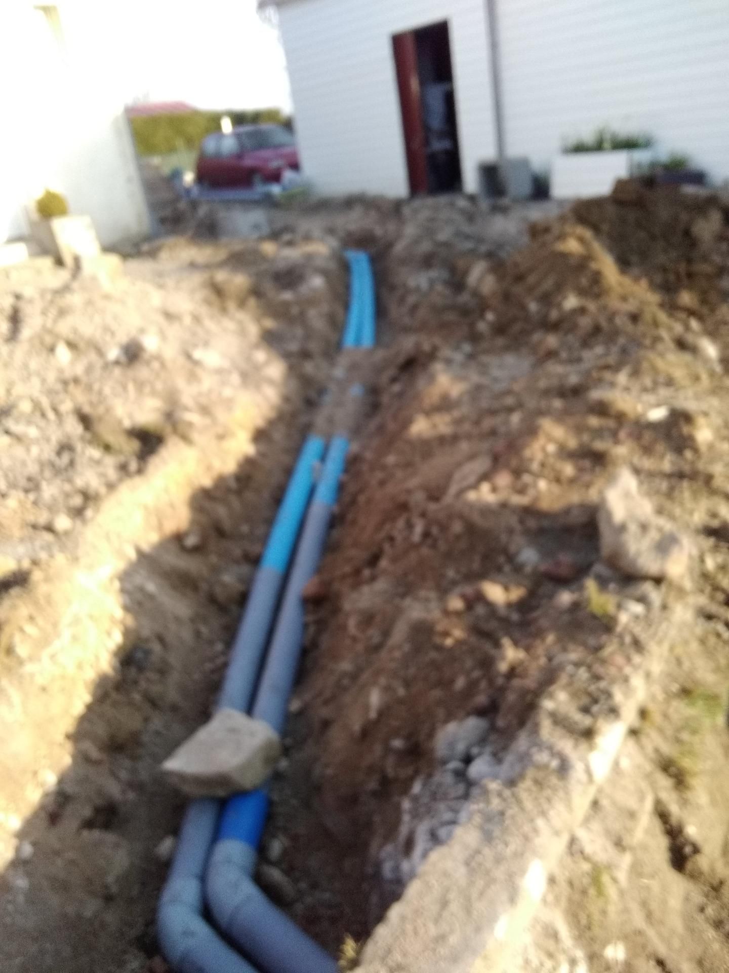 Pose de tuyaux bleu et gris pour assainissement