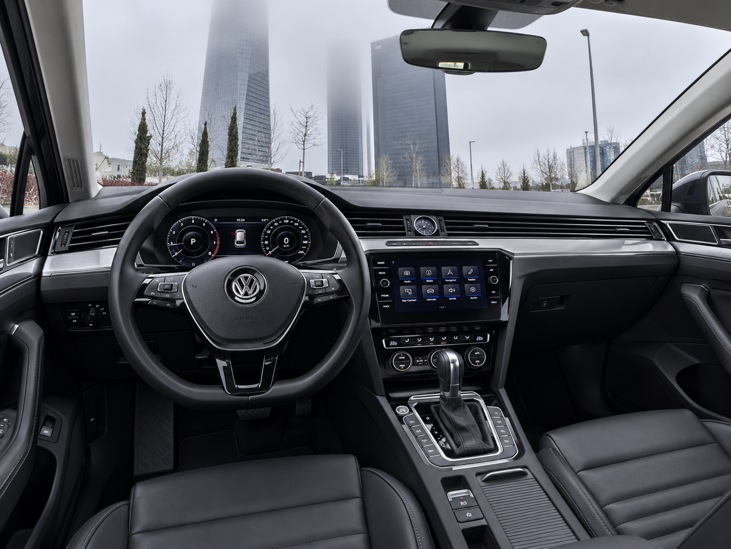 Interior de un Volkswagen con salpicadero y volante, horizonte de la ciudad visible a través del parabrisas.