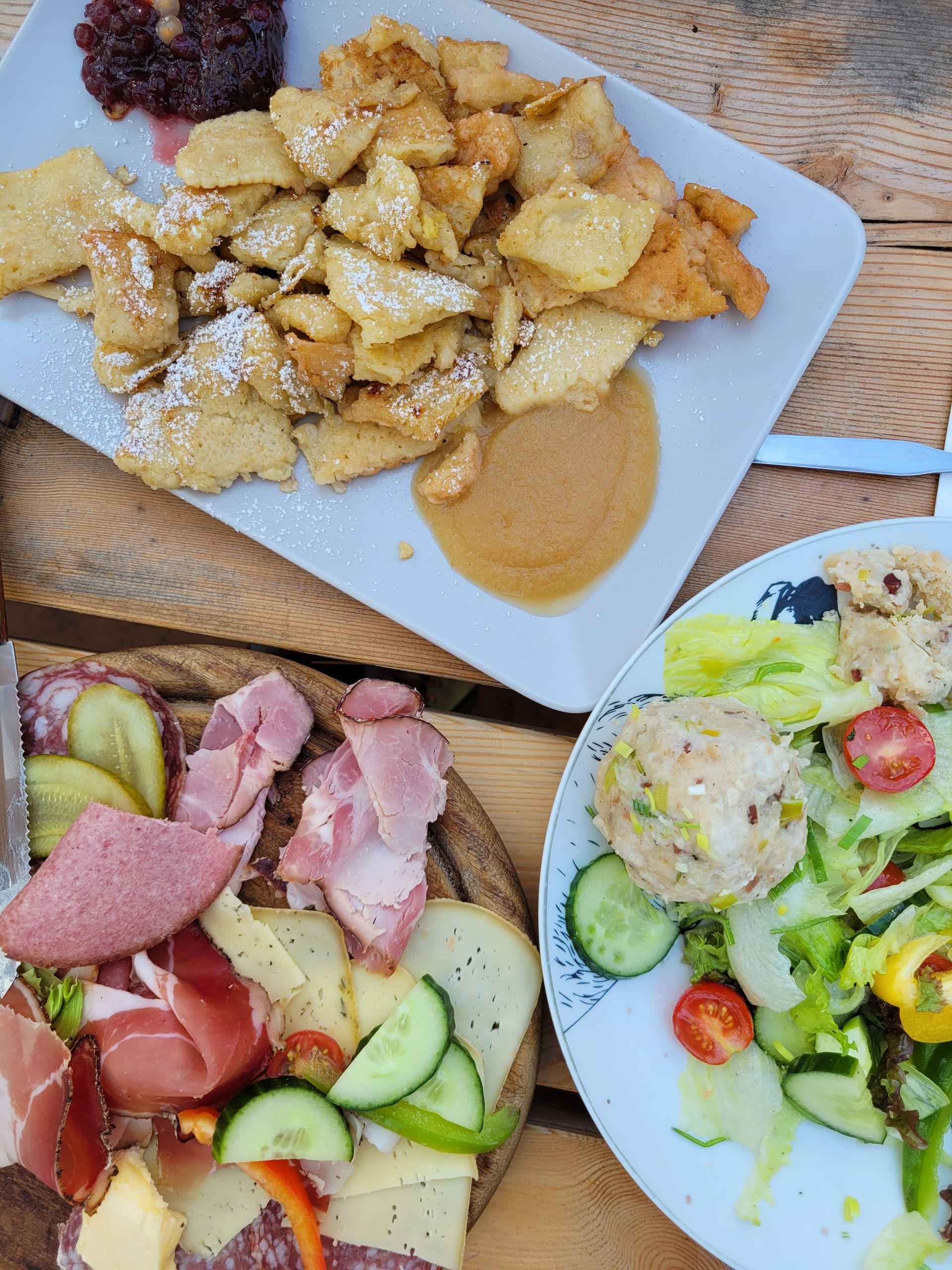 Frau mit gefalteten Händen betrachtet Geschäftsdiagramme auf einem Tisch.