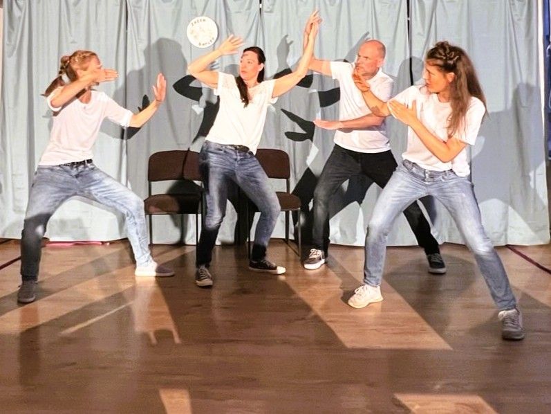 Schreibtisch mit Laptop, Monitor, Notebook, Maus, Pflanzen am Fenster.