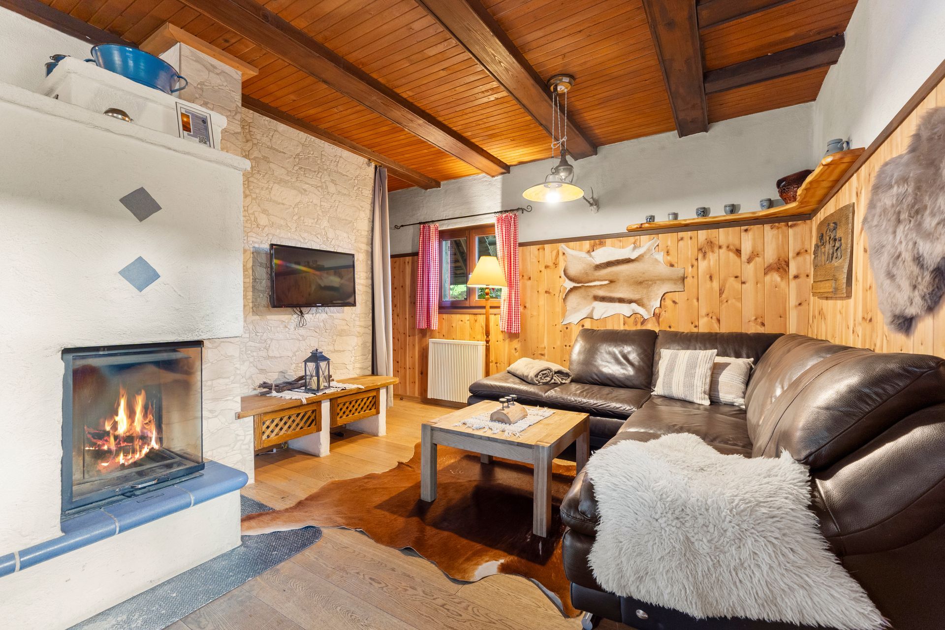 Berghütte, Ferienhütte, Ferienhaus, Wohnbereich, Couch, Wohnzimmer, TV, Kamin, Kaminfeuer