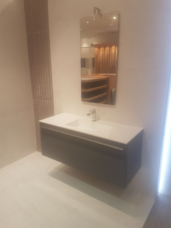 Mueble de baño flotante moderno con encimera blanca y espejo rectangular.