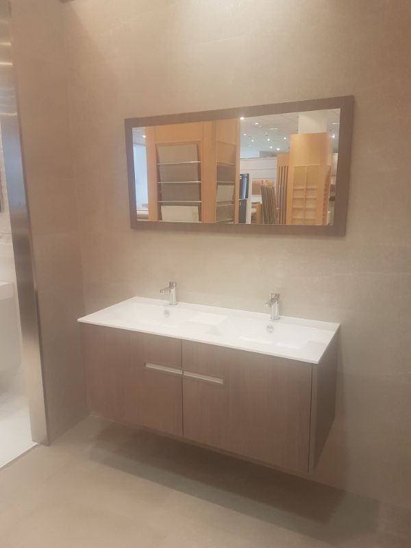 Mueble de baño con lavabo doble, espejo y mueble de dos puertas.