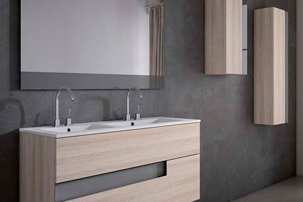 Mueble de baño con dos lavabos, espejo y dos armarios de pared contra una pared gris.