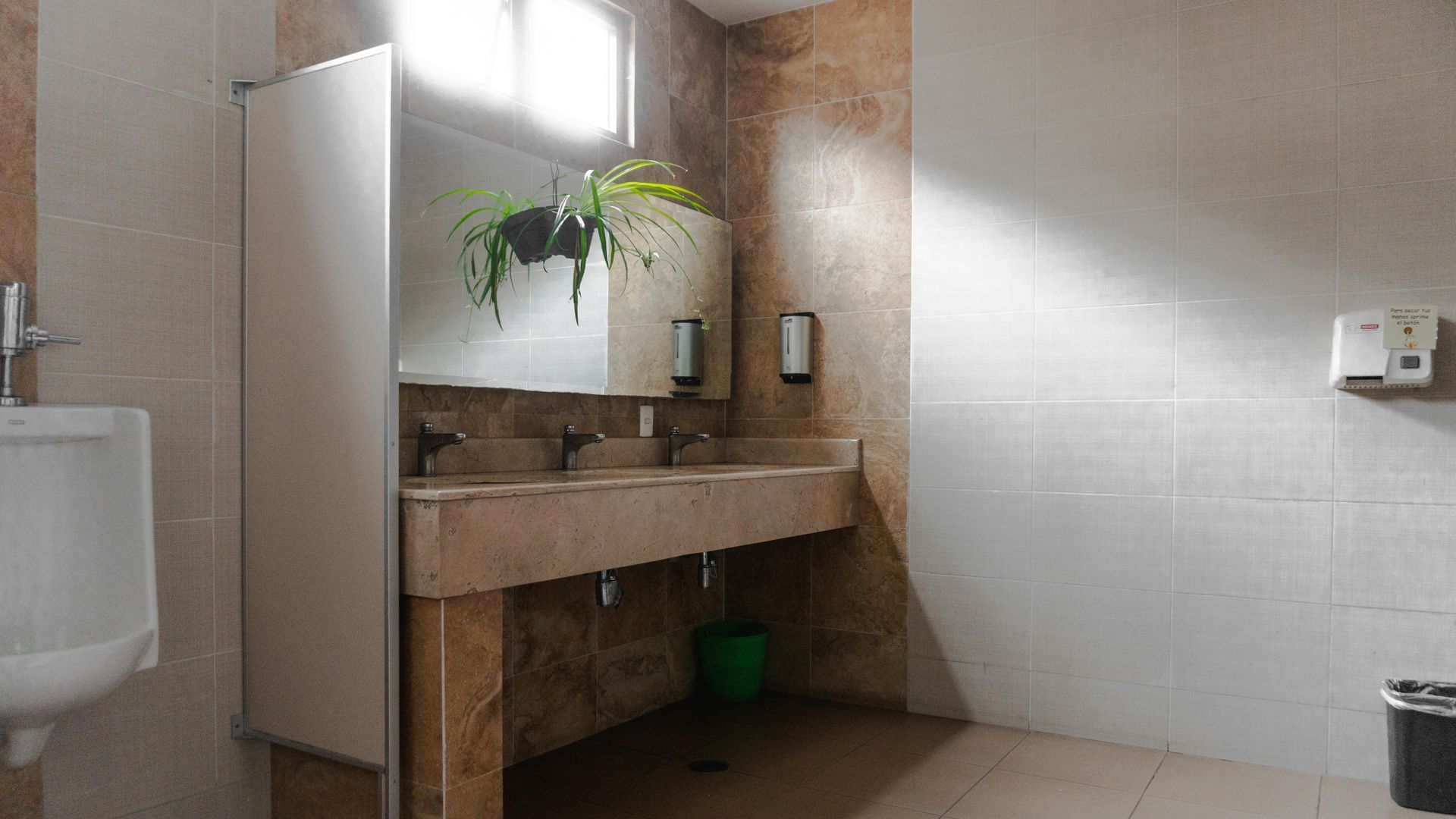 Interior de una tienda de artículos de fontanería con escritorio, estanterías y paredes rojas. Un cartel dice 