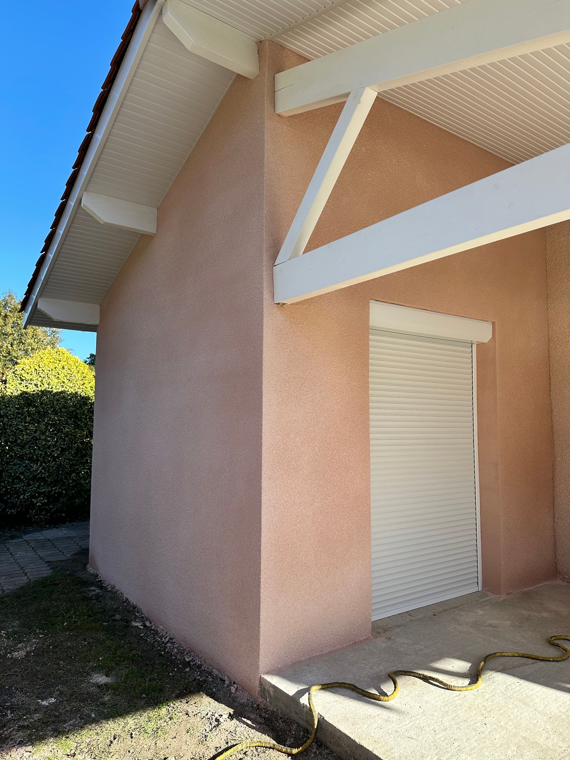 Une maison à l'extérieur en stuc rose clair.