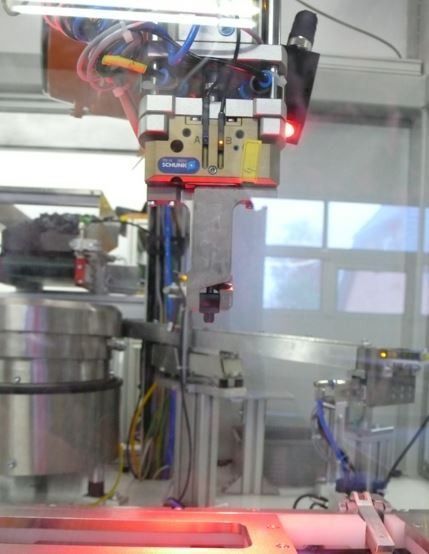 Industriemaschine in einem Labor oder einer Fabrik, mit Metallteilen, Drähten und einem leuchtend roten Licht.