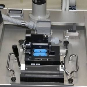 Automatisiertes Laborgerät mit blauer Probenablage und Metallgriffen in einem Arbeitsplatzfach