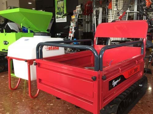 Un remolque rojo con un tanque acoplado está estacionado en una habitación.