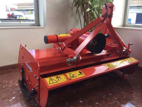 Una máquina roja está sentada en una habitación al lado de una ventana.