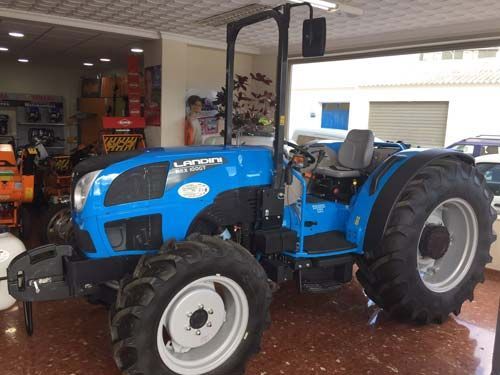 Un tractor azul está estacionado en una sala de exposición.
