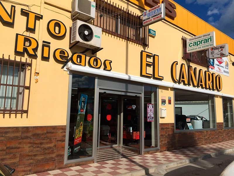 Un edificio amarillo con un cartel que dice el canario.