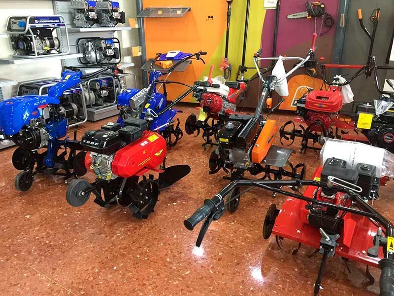 Un montón de tractores pequeños están en exhibición en una tienda.