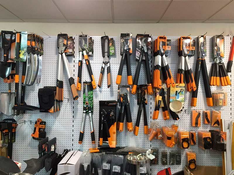 Un montón de herramientas están colgadas en la pared de una tienda.