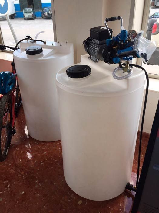 Dos tanques de plástico blanco con una bomba conectada a ellos