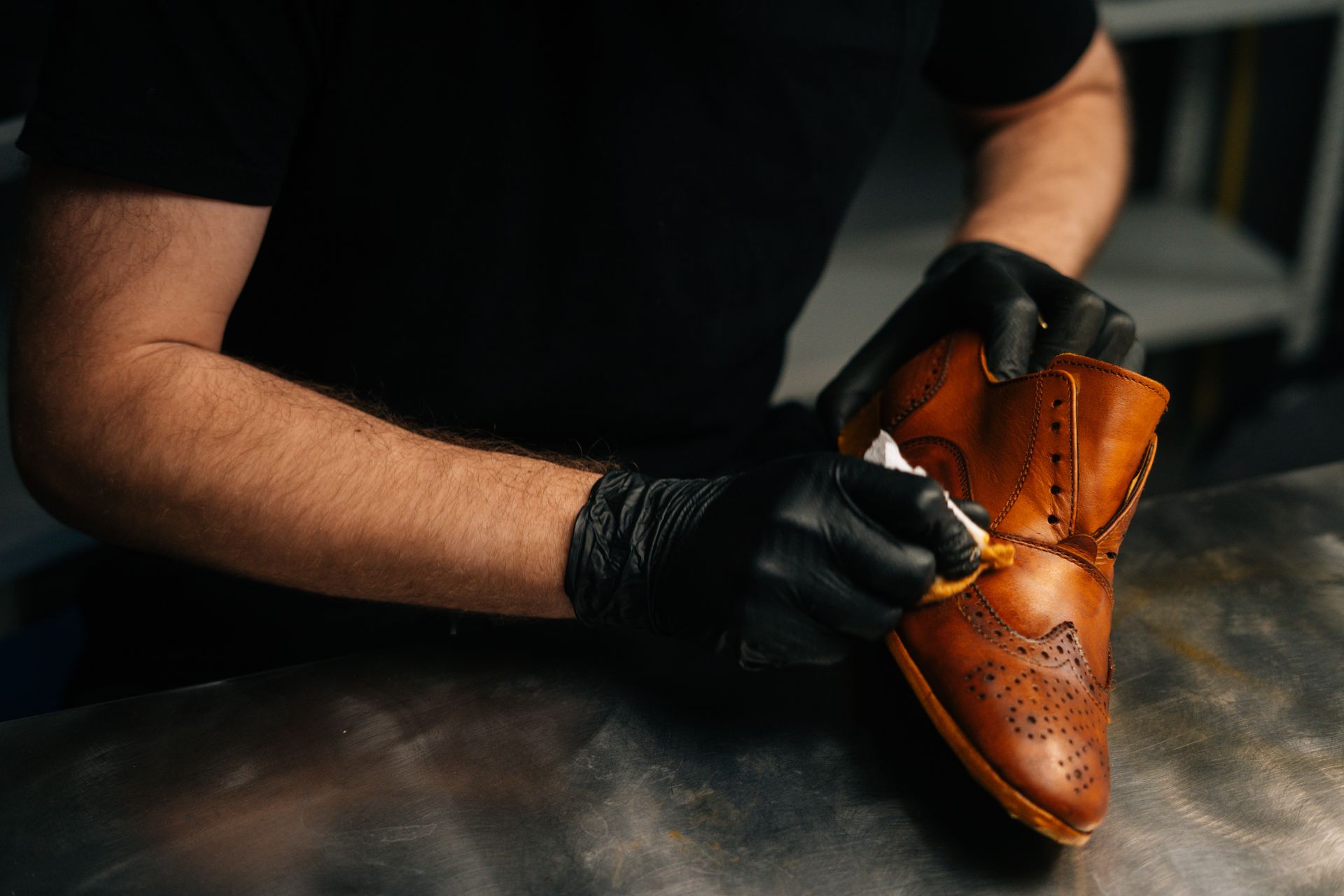 Schuster reinigt einen Schuh aus Leder