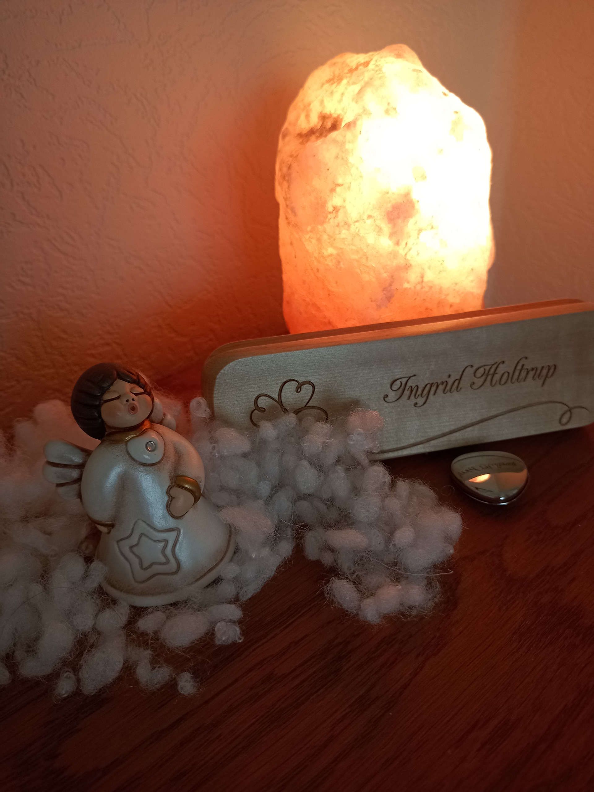 Ein Engel mit einer Salzkristalllampe auf einer Kommode