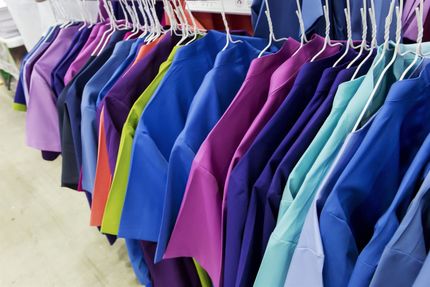 Fileiras de camisas coloridas penduradas em um cabide.