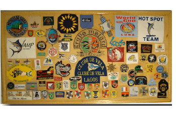 Painel de madeira com diversos patches coloridos, logotipos e emblemas.