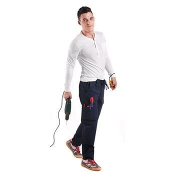 Homem segurando uma furadeira e ferramentas, vestindo calça de trabalho azul e camisa branca.