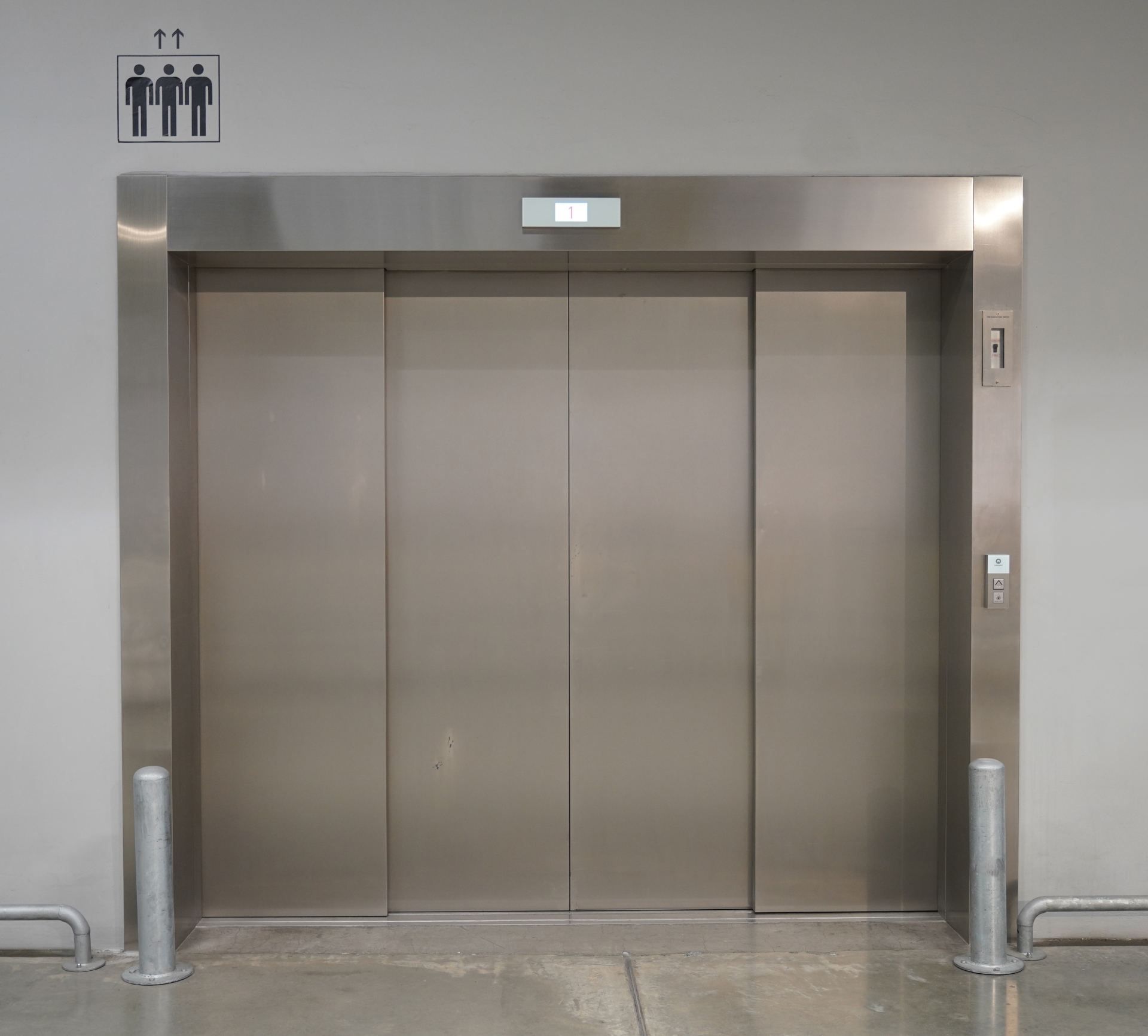 Ein Aufzug aus rostfreiem Stahl mit einem Schild an der Wand, auf dem 